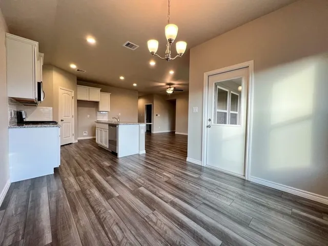 a view of kitchen with cabinets appliances and wooden floor