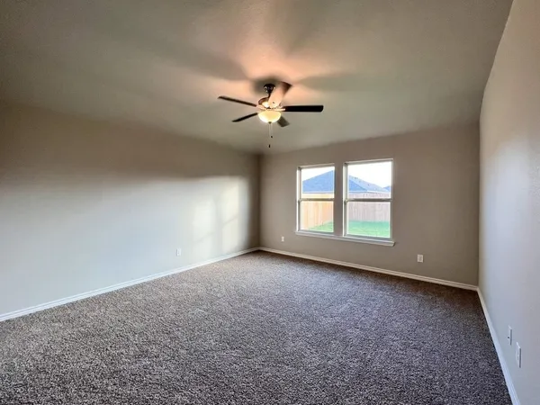 an empty room with a window and a ceiling fan