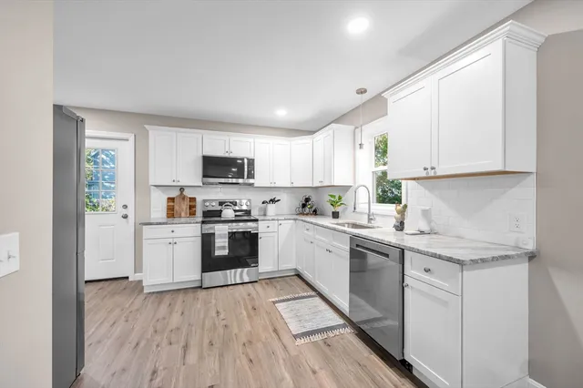 a kitchen with granite countertop white cabinets and white appliances