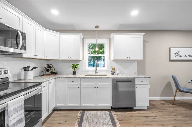 a kitchen with stainless steel appliances granite countertop a stove a sink dishwasher and a microwave oven with wooden cabinets