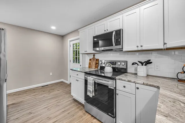 a kitchen with stainless steel appliances granite countertop a sink a stove a microwave and cabinets