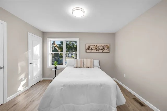 a bedroom with a bed and a large window