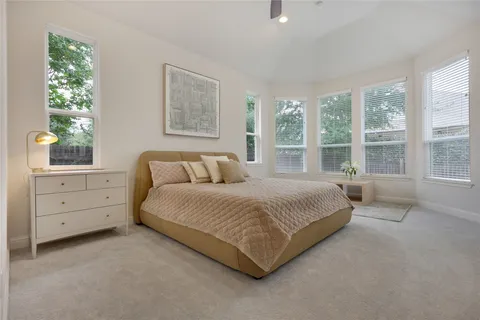 a large bed sitting in a bedroom next to a window
