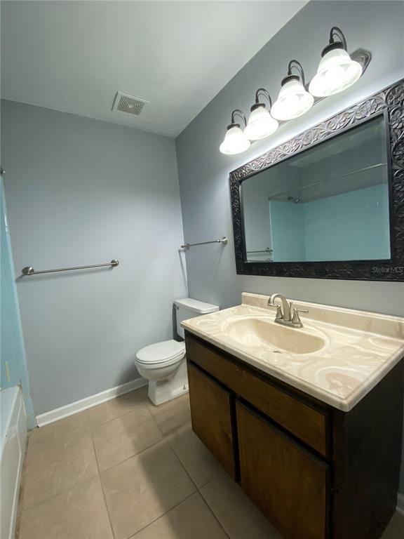 253 Northwest 3rd Street Micanopy, FL 32667 - Photo 5 of 22 a bathroom with a granite countertop sink a toilet and a mirror