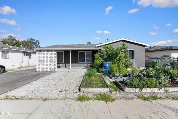 a front view of a house with a yard and potted plants