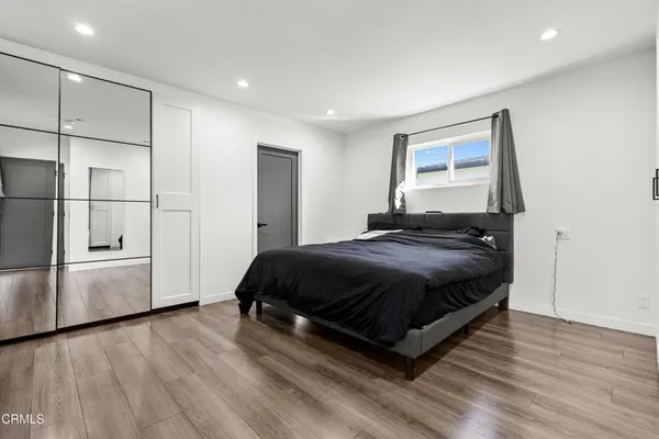 a spacious bedroom with a bed and a refrigerator