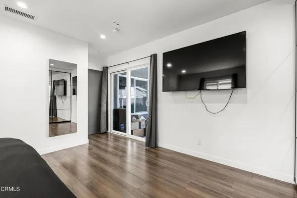 a view of empty room with wooden floor