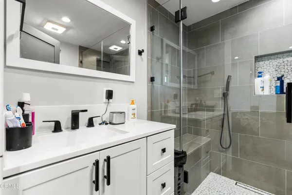 a bathroom with a shower sink and mirror