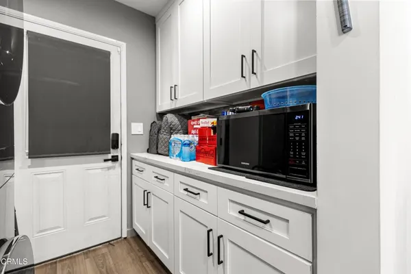 a kitchen with white cabinets and black appliances