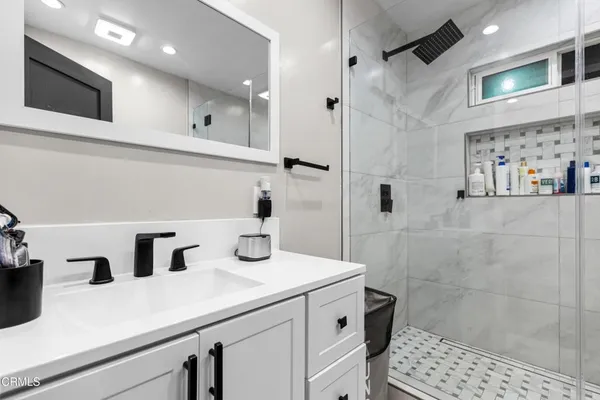 a bathroom with a sink a toilet and shower
