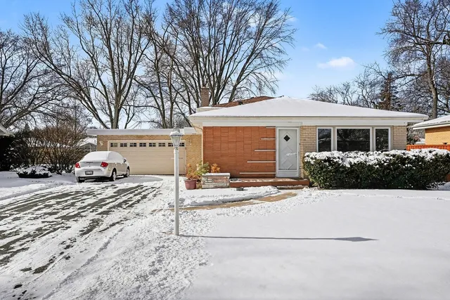 a view of a house with snow on the side of the road