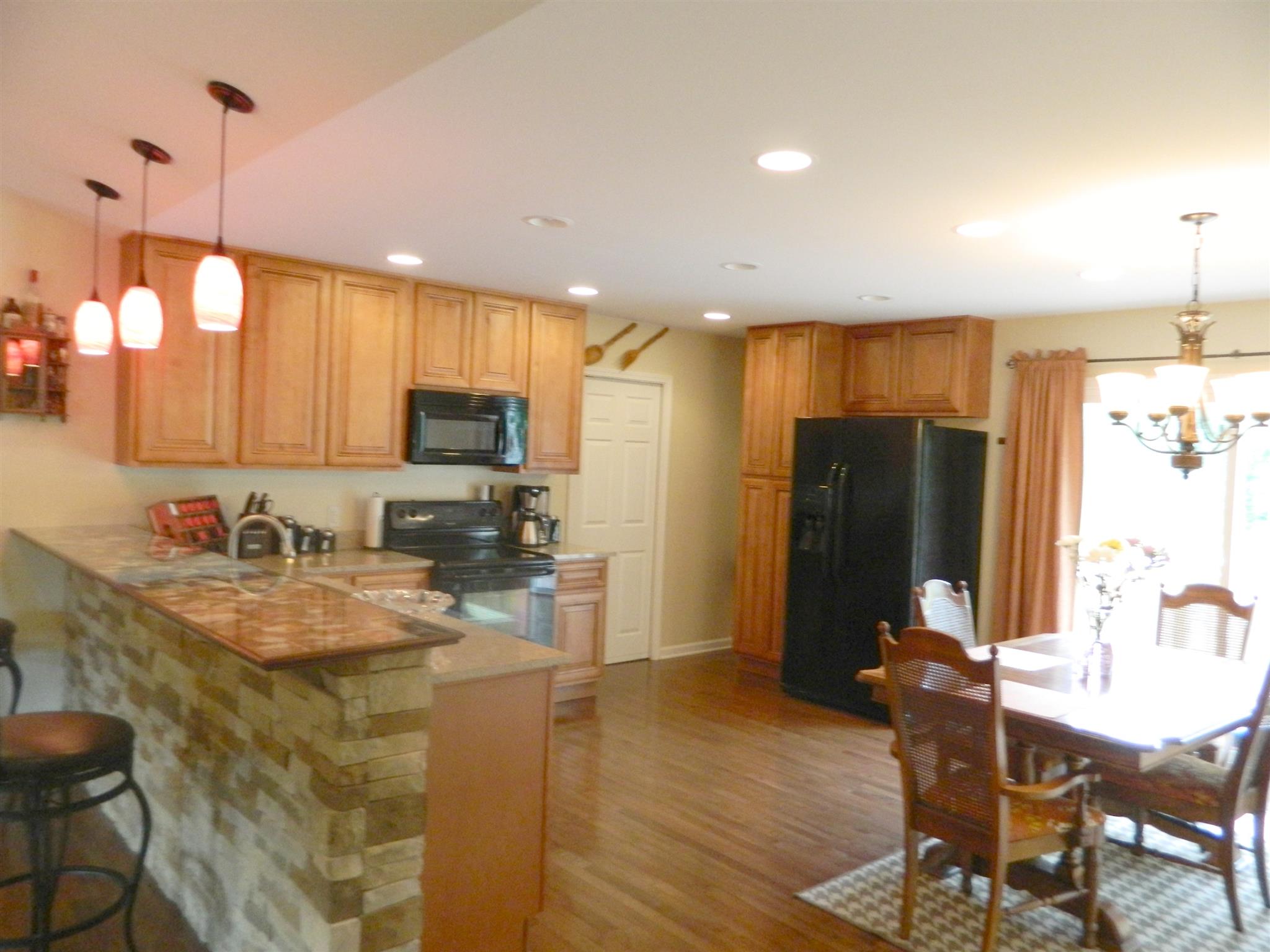 430 Kaiser Road Dickson, TN 37055 - Photo 6 of 13 a kitchen with kitchen island granite countertop a stove a refrigerator a sink a dining table and chairs with wooden floor