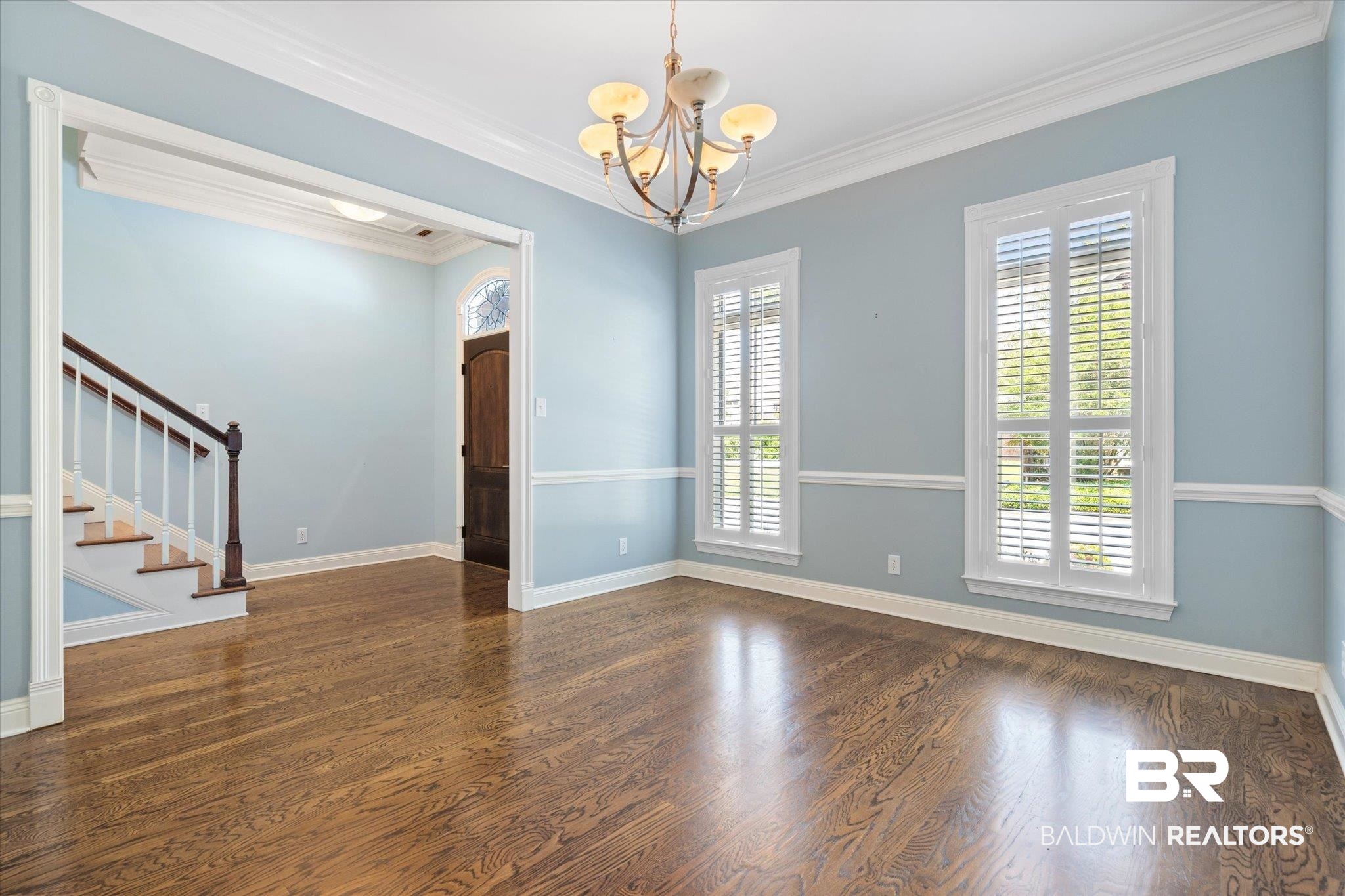 107 Fielding Place Mobile, AL 36608 - Photo 3 of 27 Unfurnished room featuring a chandelier, stairway, wood finished floors, ornamental molding, and baseboards