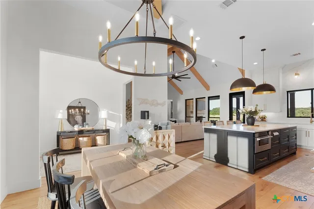 a living room with kitchen island furniture a chandelier and kitchen view