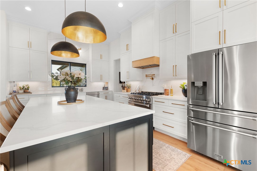 871 Blackbuck Ridge Drive Lampasas, TX 76550 - Photo 13 of 48 a kitchen with stainless steel appliances granite countertop a sink a stove and a refrigerator