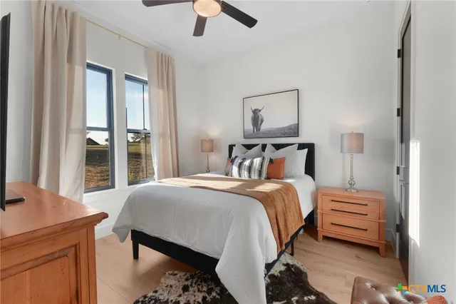 a bedroom with a bed a chandelier and a window