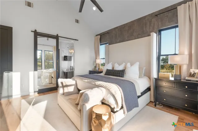 a bedroom with a bed and large windows