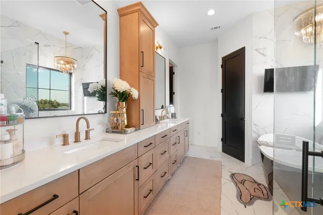 a bathroom with a double vanity sink a mirror and a bathtub