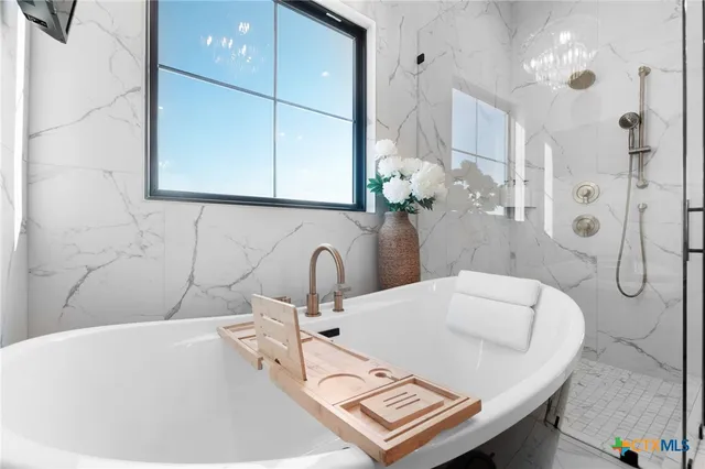 a bathroom with a tub sink and mirror