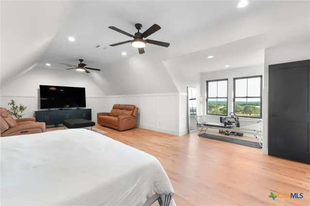 a bedroom with a bed a couch and large window