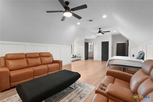 a living room with furniture ceiling fan and a rug