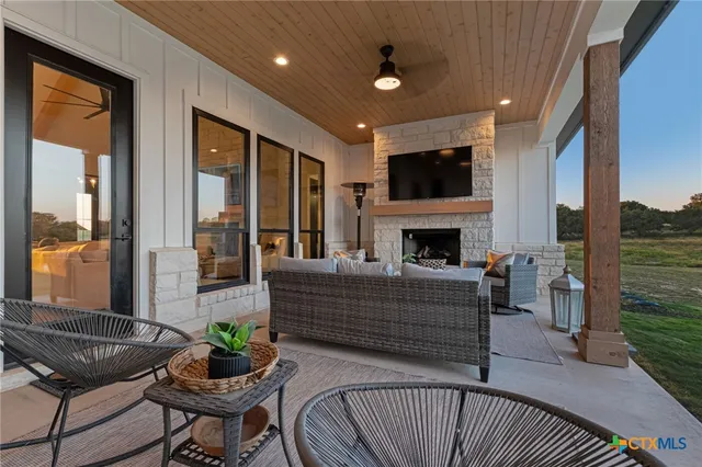 a living room with furniture a flat screen tv and a fireplace
