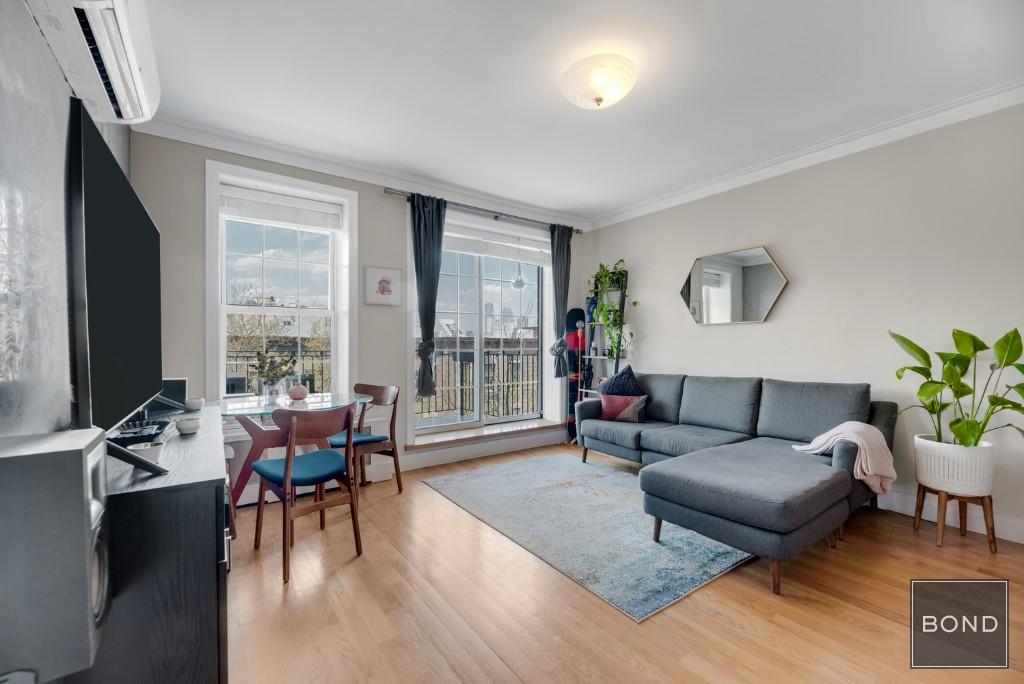 150 Java Street, Unit 5A Brooklyn, NY 11222 - Photo 1 of 1 a living room with furniture and a flat screen tv with wooden floor