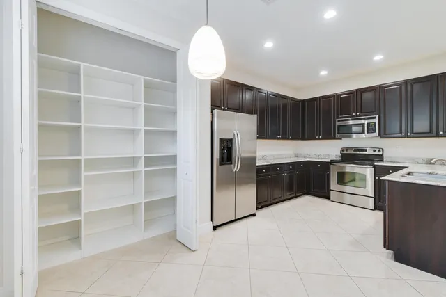 a kitchen with granite countertop a refrigerator and a sink