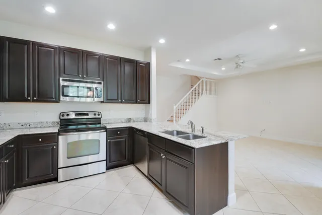 a kitchen with wooden cabinets stainless steel appliances and a sink