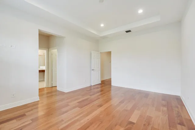 a view of an empty room with wooden floor