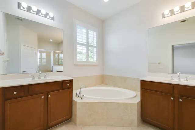 a bathroom with a tub sink and mirror