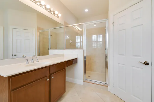 a bathroom with a shower sink and mirror