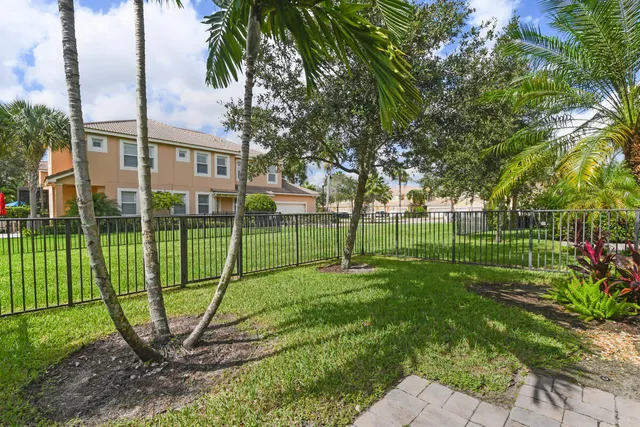a view of a park with swings and a palm tree