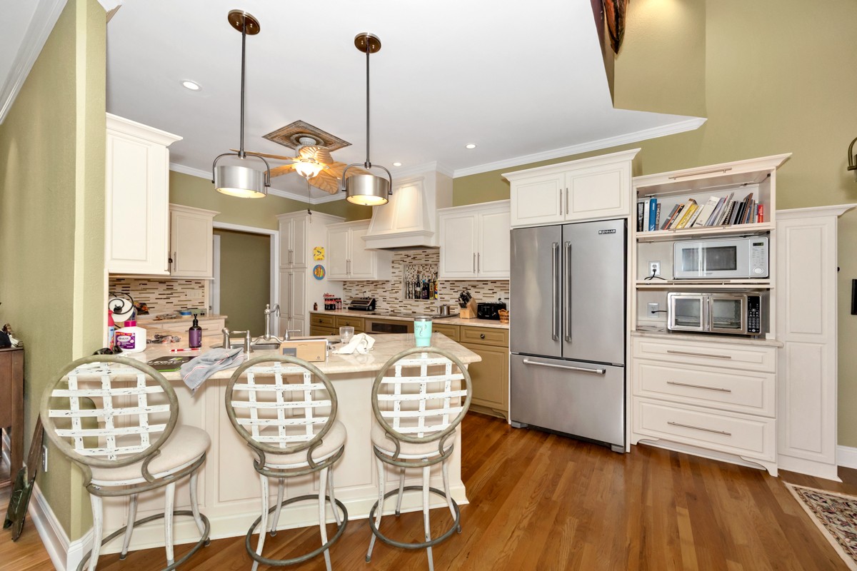 332 Riverfront Road Rogersville, AL 35652 - Photo 10 of 52 a kitchen with stainless steel appliances granite countertop a refrigerator a microwave oven a dining table and chairs with wooden floor