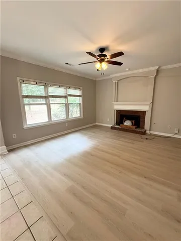 an empty room with windows and fireplace