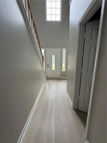 a view of a hallway with wooden floor and staircase