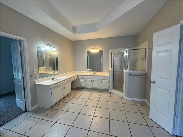 a large white kitchen with a sink and refrigerator