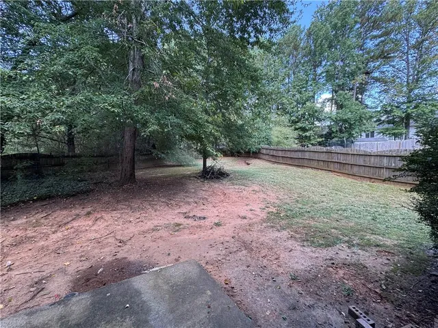 a view of a yard with trees in the background