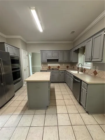 a kitchen with a sink a stove top oven and cabinets
