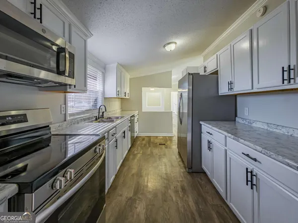 a kitchen with stainless steel appliances granite countertop a stove a sink and a refrigerator