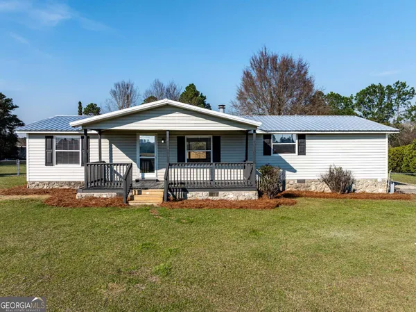 a front view of a house with a yard and trees
