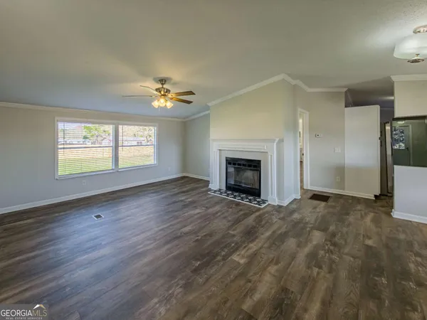 an empty room with windows and fireplace