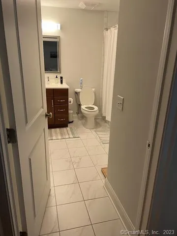 a bathroom with a sink a toilet and a mirror