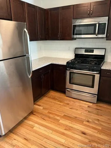 a kitchen with granite countertop a stove and a microwave
