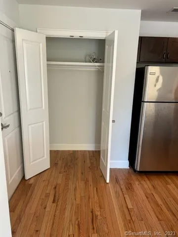 an empty room with wooden floor and entrance