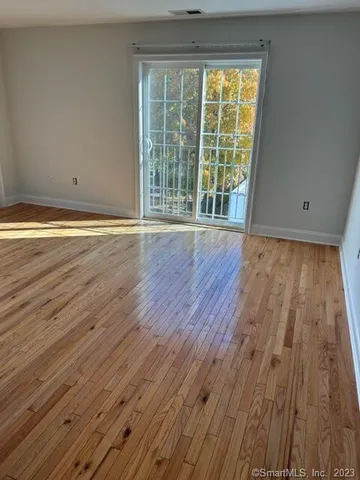 a view of a room with wooden floor and large windows