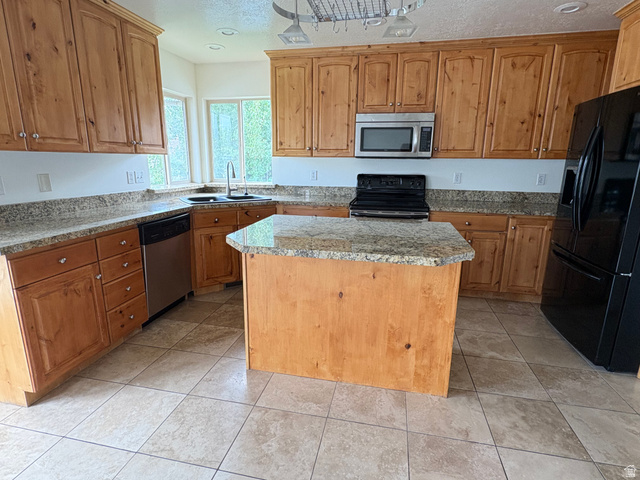 665 West State Road Lehi, UT 84043 - Photo 4 of 30 Kitchen featuring light wood cabinetry, stone countertops, a central island, stainless steel microwave, and tile flooring