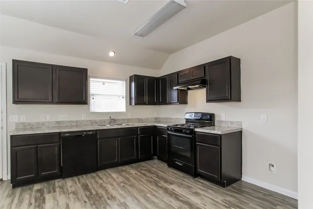 a kitchen with stainless steel appliances granite countertop a sink stove and microwave