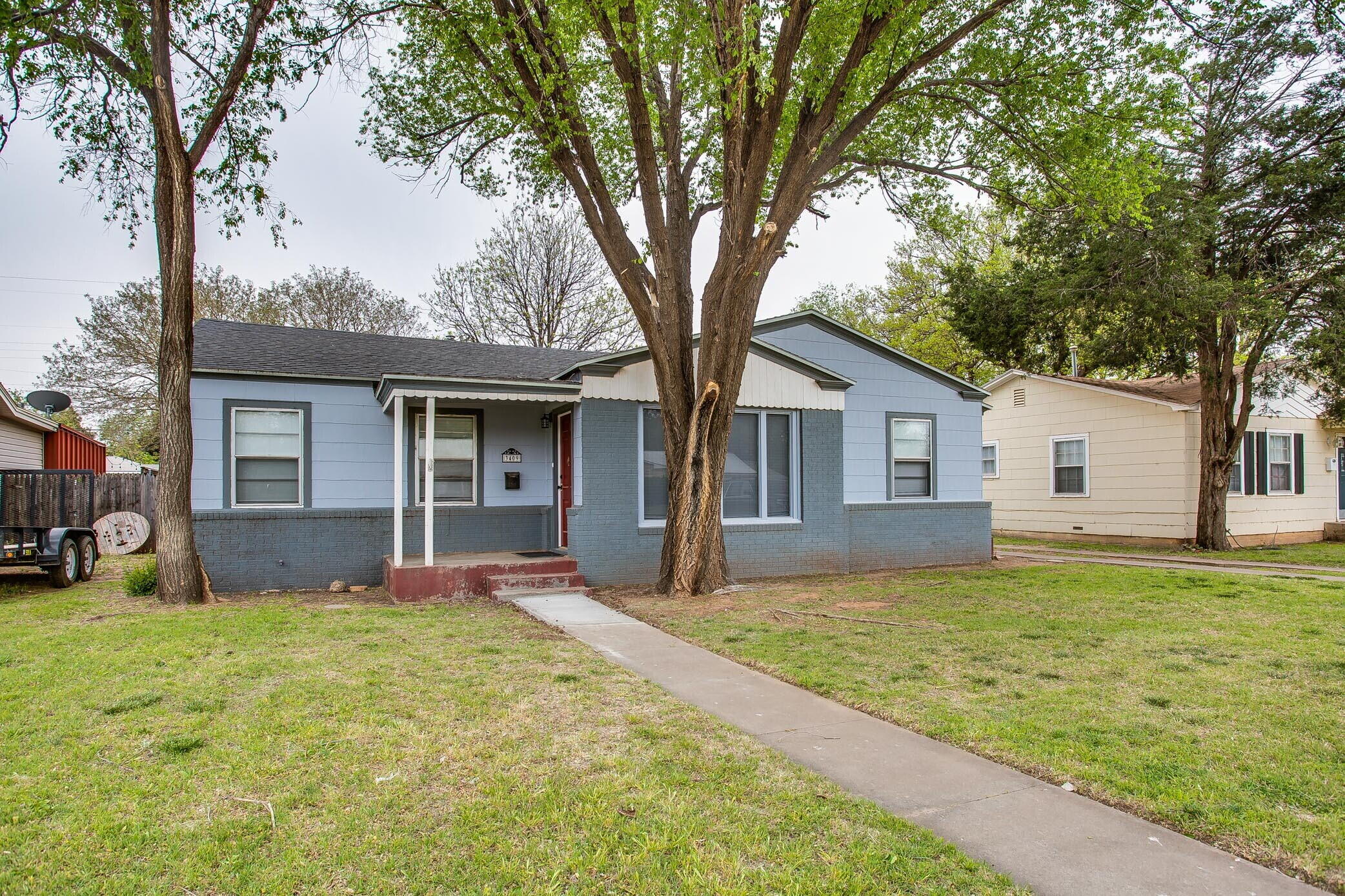 a front view of a house with a yard and trees