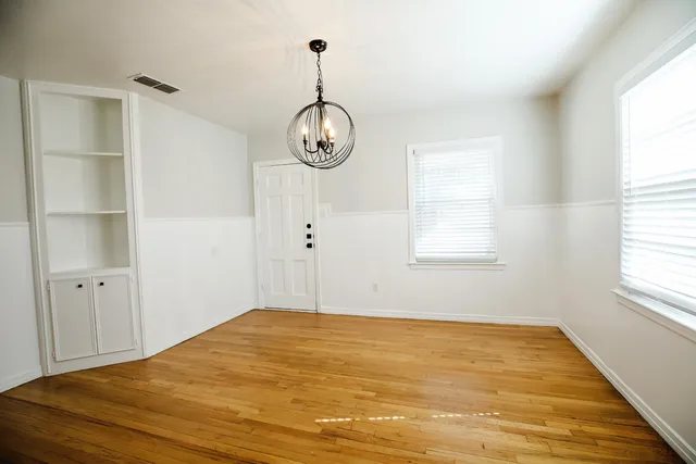 a view of empty room with wooden floor and window